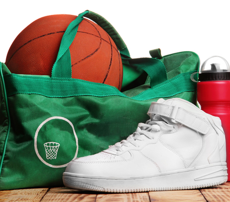 High white sneakers , Sport bag for basketball, Basketball ball inside the bag, sport bottle with water near.Top of photo white background down wooden background.Background.Concept basketball trainingの写真素材