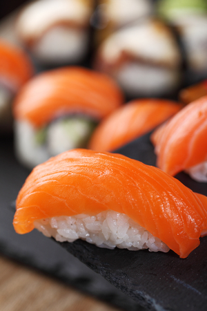 Sashimi sushi set with Philadelphia roll sushi on black slate plate background.Nigiri.Closeup.Selective focusの写真素材