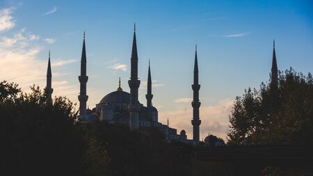 Blue Mosque in Istanbul, backlight at sunrise.  The main subject is the silhouette of the Mosque, on the background there is a blue sky with some clouds.の写真素材