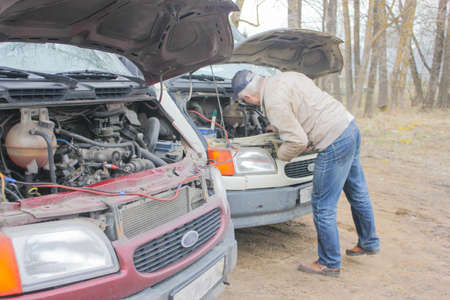 Two trucks standing in a row ,goes to the battery. Repair of machines. Do not start the car. car is...
