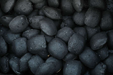 Close-up of an oval-shaped unburned charcoal grill drenched in fuel. Top view.の写真素材