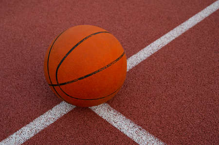 Basketball ball placed on urban street (outdoor) basketball court.の写真素材