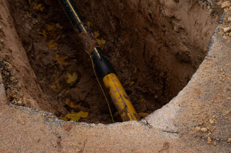 An outcrop showing a metal communication pipe during road construction.