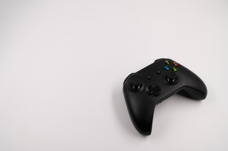 Close-up of ab lack wireless game controller with joysticks on an isolated white background.の写真素材