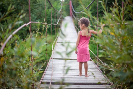 the girl in the pink dress on the bridge villageの写真素材