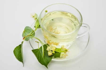 cup of tea and linden flowers on a white backgroundの写真素材