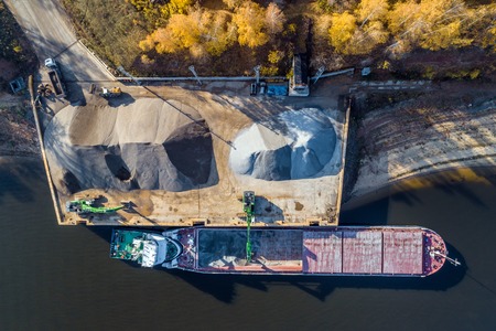 unloading of rubble from the ship in the river portの写真素材