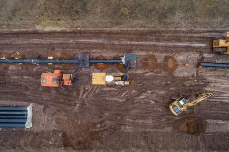 laying the pipeline with an excavator. Autumn, shooting from a drone. Earthworks, infrastructure...