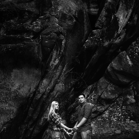 Young beautiful couple in jeans and shirts for a walk in the mountainsの写真素材
