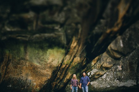 Young beautiful couple in jeans and shirts for a walk in the mountainsの写真素材