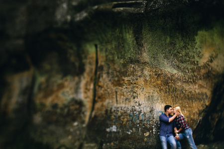 Young beautiful couple in jeans and shirts for a walk in the mountains. Romantic kissの写真素材
