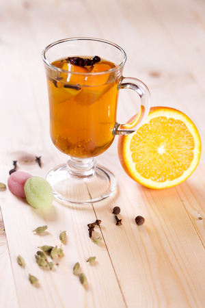Tasty fragrant warming drink grog with rum, lemon and fruit in a glass on the table of the cafeteria. Hot Citrus alcoholic cocktail.の写真素材