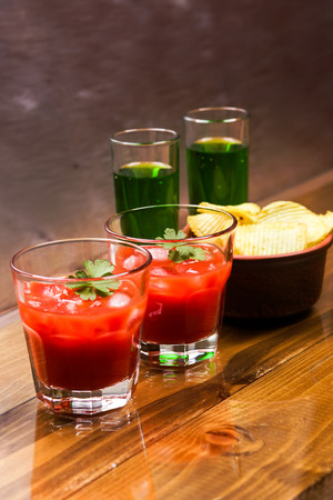 Tomato alcoholic coctail with crispy potato chips and liquorの写真素材