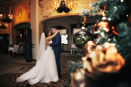 Happy couple of newlyweds hugging, christmas foregroundの写真素材