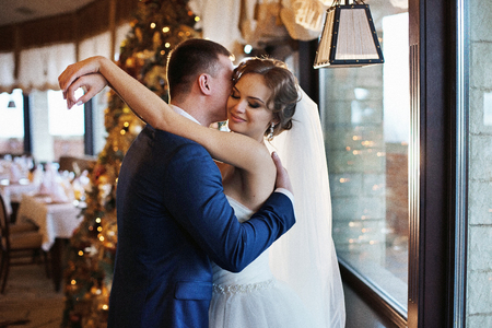 Happy couple of newlyweds hugging, christmas backgroundの写真素材