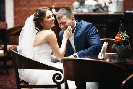 Happy bride groom laughing at restaurant table closeupの写真素材