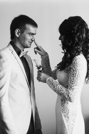Bride puts a lily on fiance's jacketの写真素材