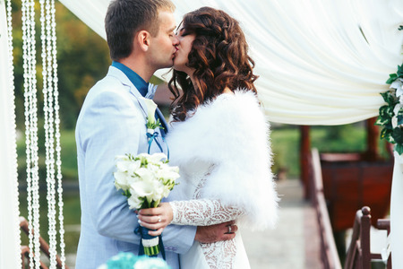 Bride and fiance kissing in the front of wedding altarの写真素材