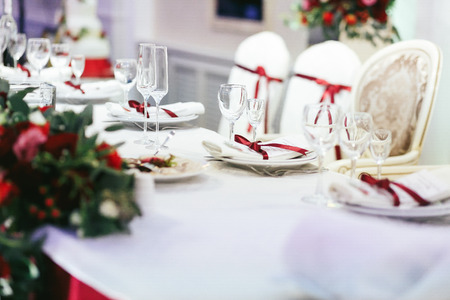 White wedding table set decorated with red ribbonsの写真素材