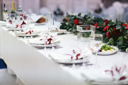 Table covered with white cloth served for a festive dinnerの写真素材
