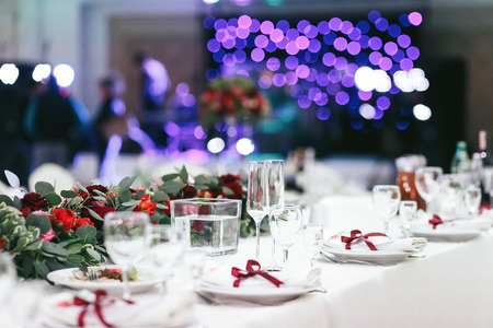 White table set for dinner with empty wineglassesの写真素材