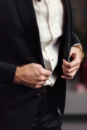 Man buttons up his black suitの写真素材