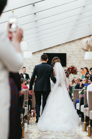 Newlyweds walk along the aisle to the altarの写真素材