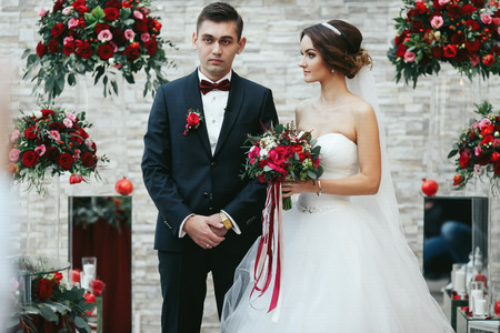 Bride look dreamy at the fiance among the red bouquetsの写真素材