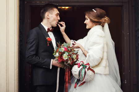 Bride give a fiance a chocolate in the front of the church's doorの写真素材