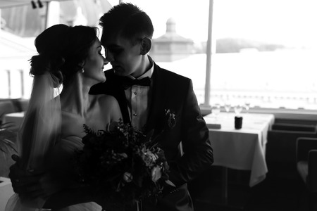 A moment of love between bride and fiance in empty restaurantの写真素材