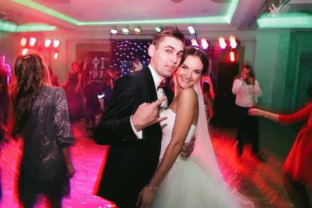 Fiance playing fool while dancing with a brideの写真素材