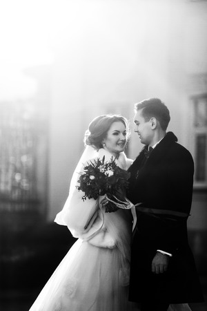Bride hugs fiance's hand in the light of rising sunの写真素材