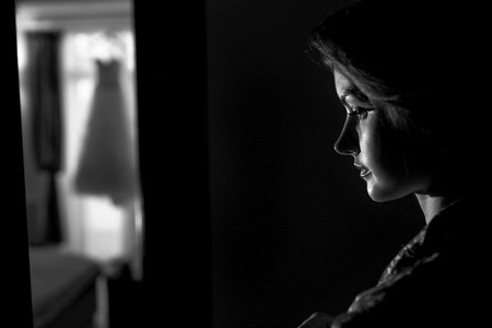 Bride stands thoughtfully in the dark roomの写真素材