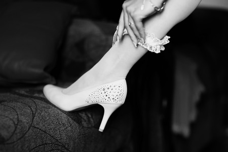 Lady puts a lace garter on the leg