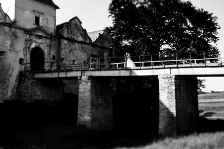 Couple stands on the old bridge above the precipiceの写真素材