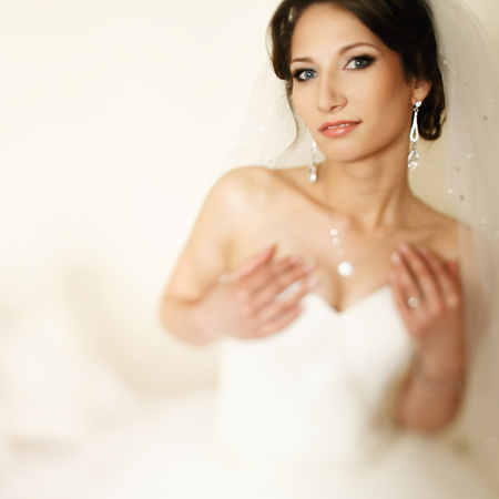 Bride holds her hands on a chest and looks temptingの写真素材