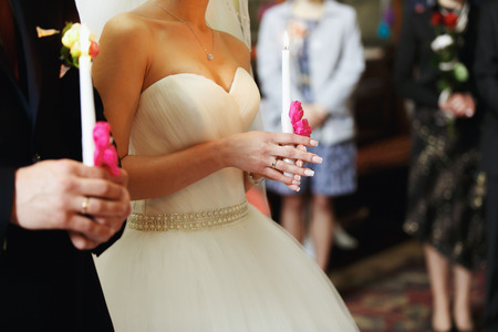 Bride and fiance hold candles during the wedding ceremonyの写真素材