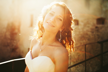 Bride smiles and shines in the light of sunの写真素材