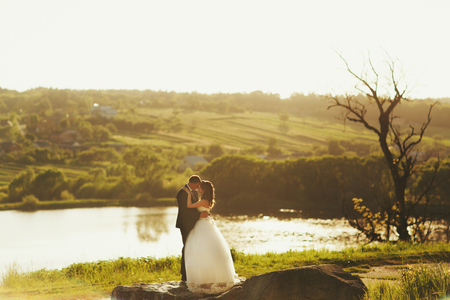Just married stand calm on the stone behind a lakeの写真素材