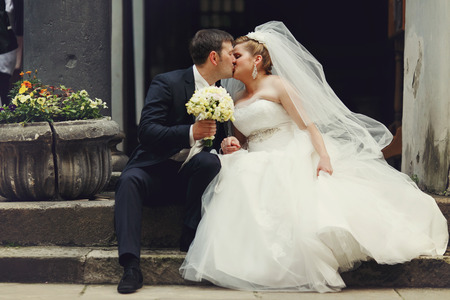 Bride and groom kiss on the old stone stairsの写真素材
