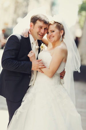 Happy newlyweds pose somewhere on the streetの写真素材