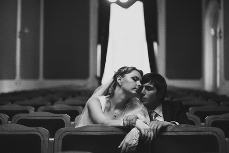 Couple daydreams while sitting on the chairs in the theatreの写真素材