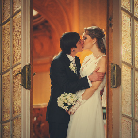 A tender kiss of newlyweds in the entrance to the hallの写真素材