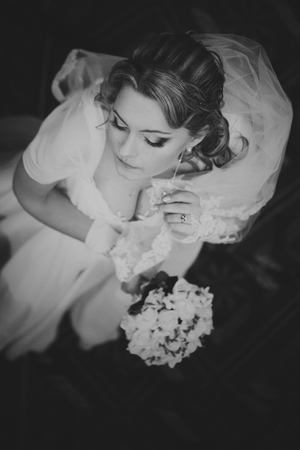 Bride plays with her long earrings and veilの写真素材