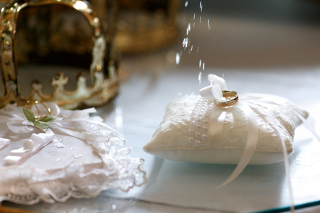 Wedding rings on the white pillow being blessed with a holy waterの写真素材