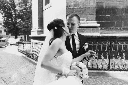 Groom leads a bride to the church and she kisses himの写真素材