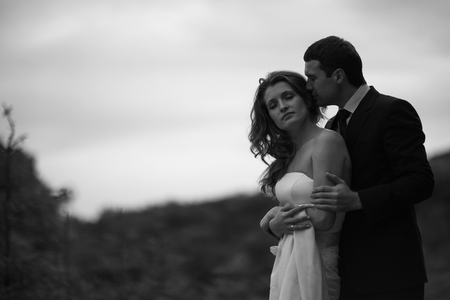 Man kisses lady's head and holds her naked shouldersの写真素材