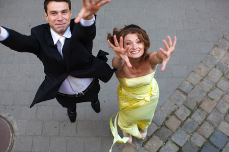 Happy couple jumps up with rose handsの写真素材