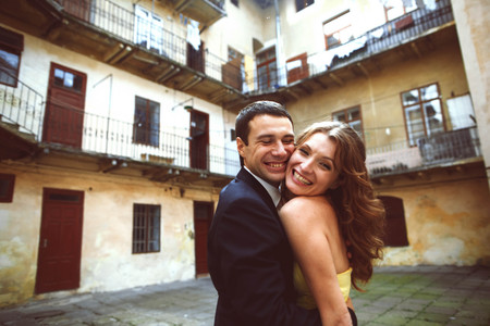 Happy couple smiles in the court of old houseの写真素材