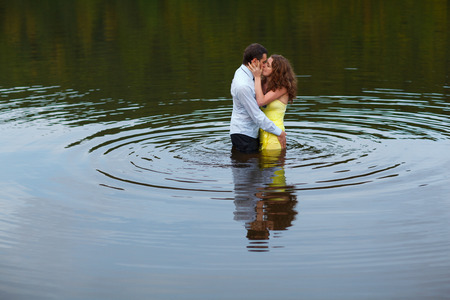 Man kisses a woman standing in waterの写真素材